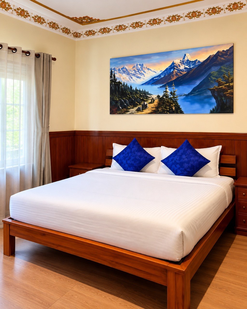 King bed with blue cushions and a mountain painting